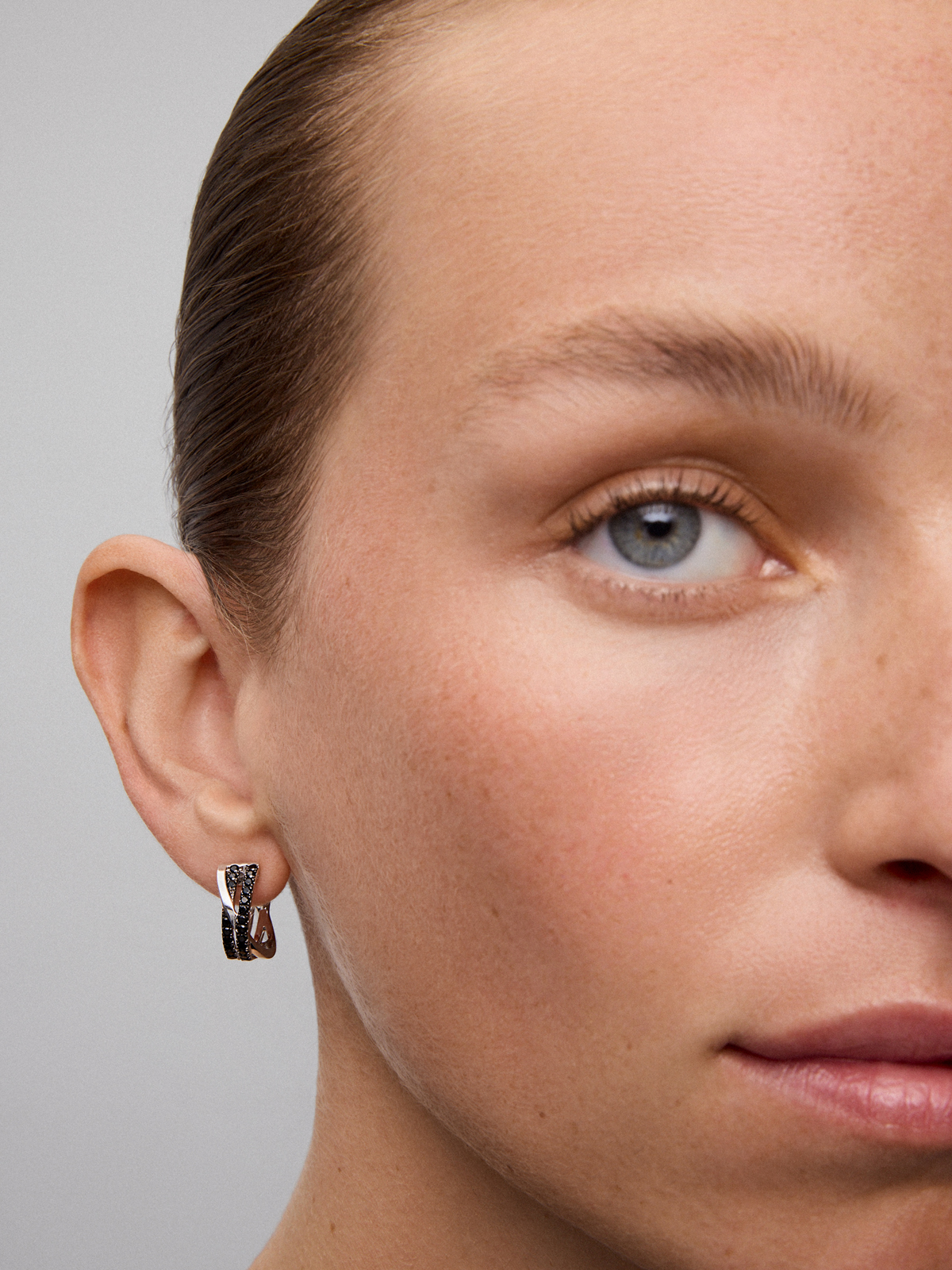 Double crossed hoop earrings made of 925 silver with spinels.